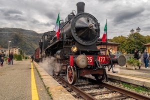 locomotiva, nuvole, bandiere, treno, rotaie, ruote, binari, cielo, vagoni, persone, fumo, nero, stazione, giallo, lampioni, alberi, rosso, bandiera, case, respingenti, ferrovia, montagne